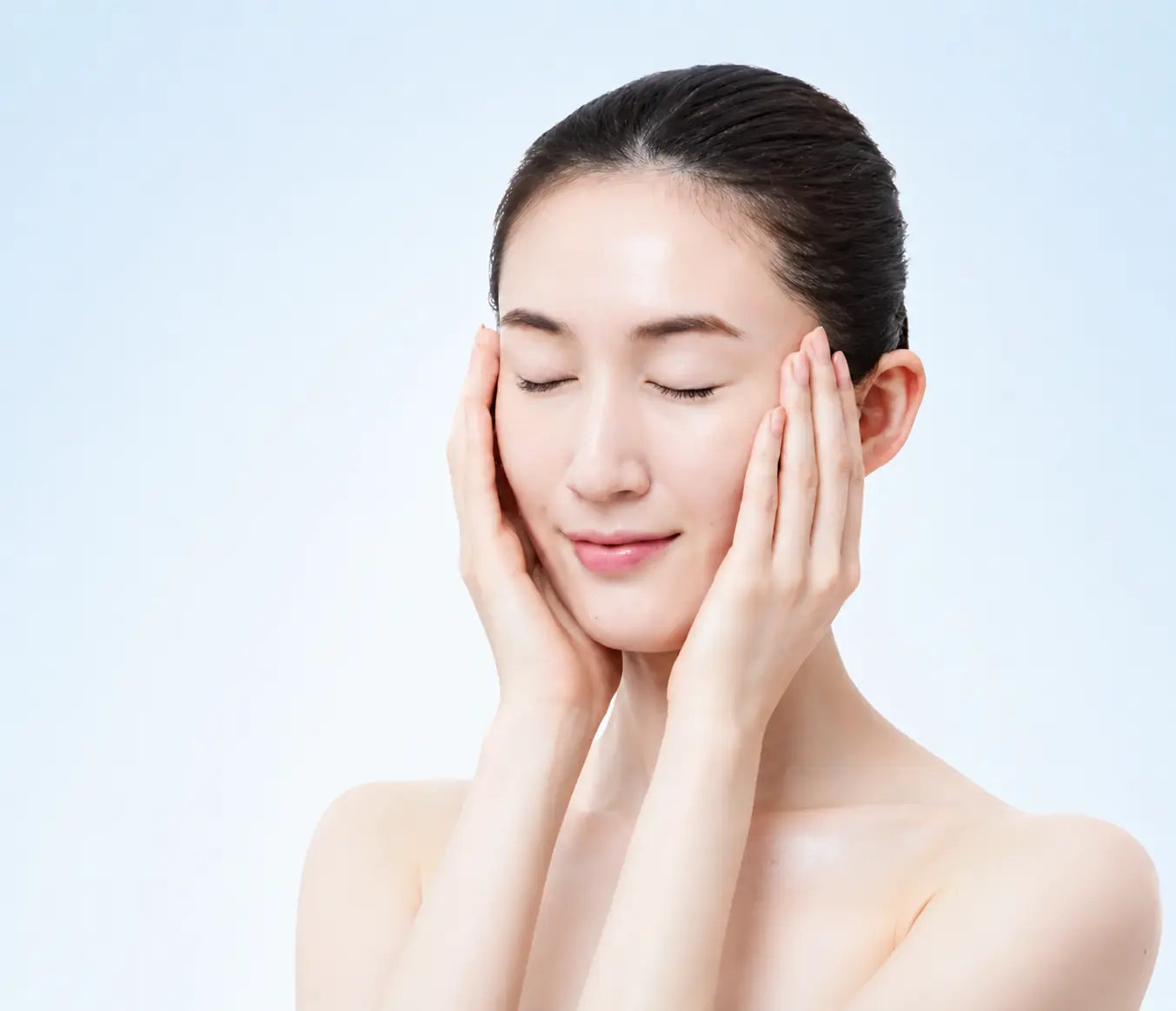 頬に手を添え、潤いを感じる女性